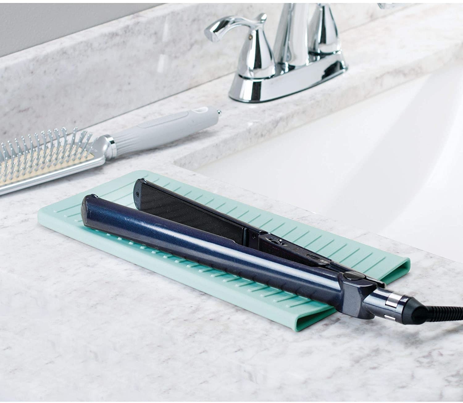 A flat iron on the pouch on a bathroom counter