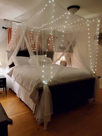 white canopy over a bed with fairy lights