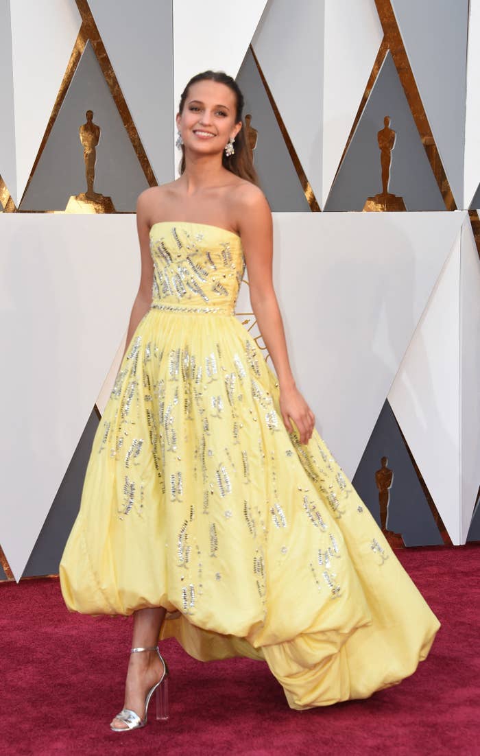 Alicia Vikander on the red carpet in a strapless, light-colored, billowy, bedecked gown