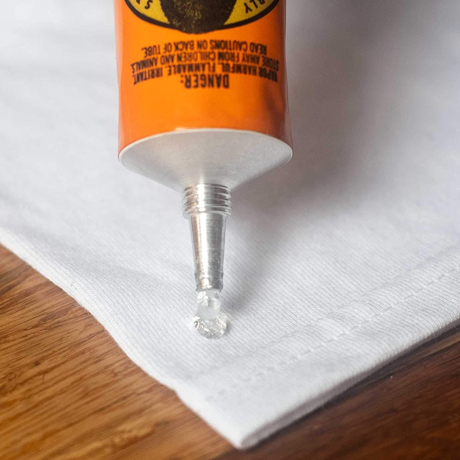 a person squeezing the glue onto fabric