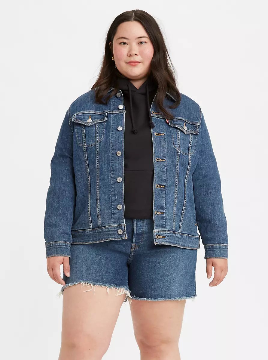 A person wearing a denim jacket with matching shorts