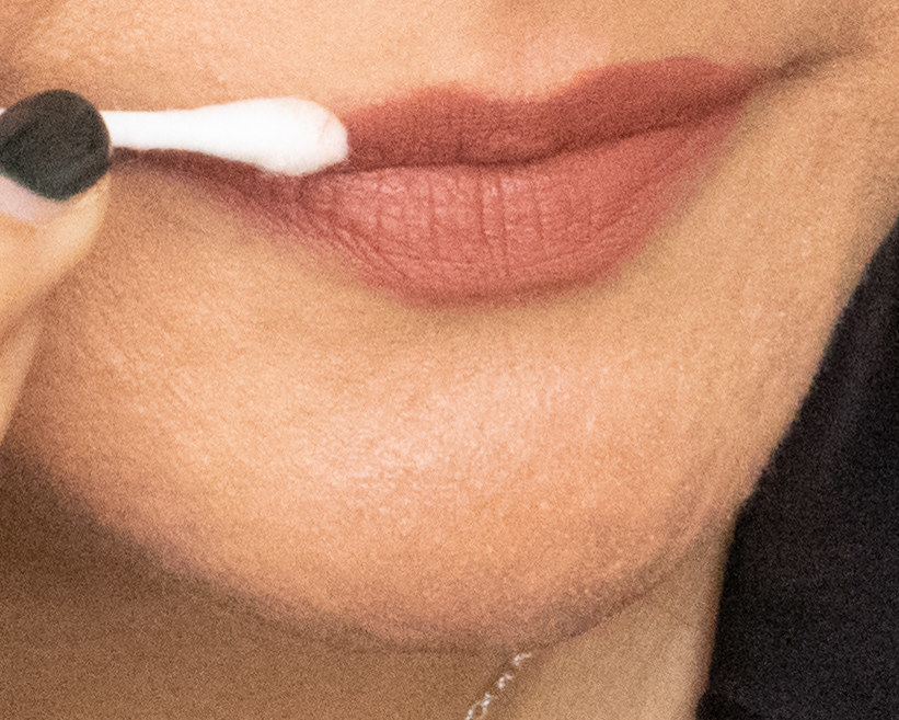 image of a woman using q-tip tp clean around the edges of her lips after using too much lipstick