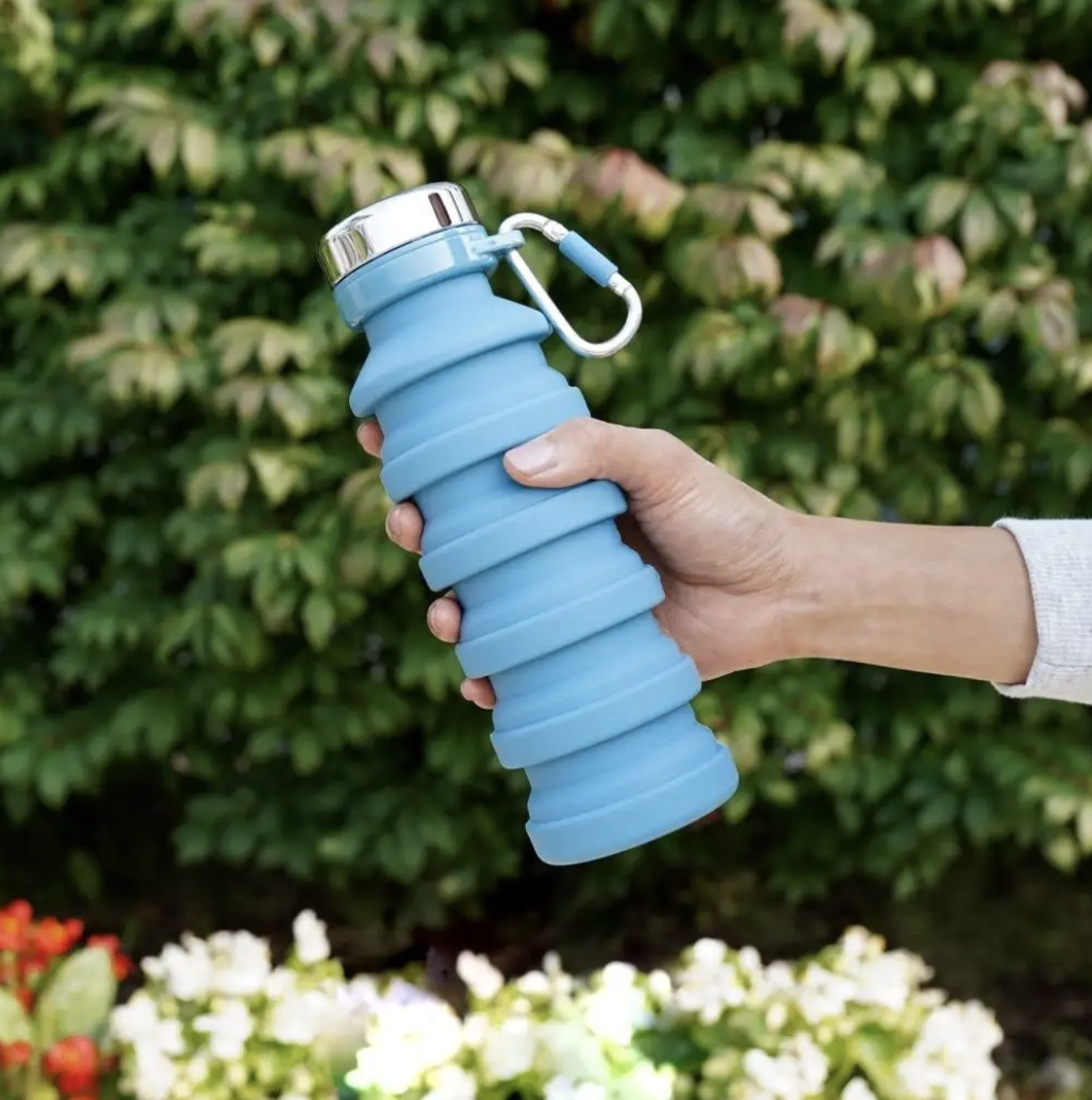 a person holding up the collapsible water bottle