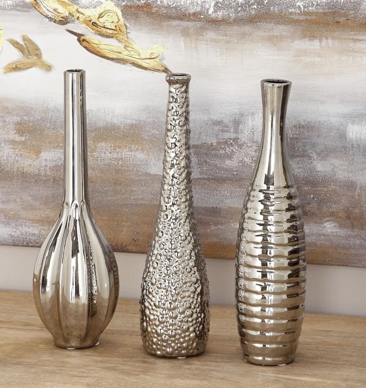 the three silver vases each with a different oblong shape and texture