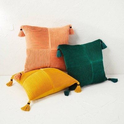 Three of the throw pillows in the colors Terracotta, Dark Green, and Gold