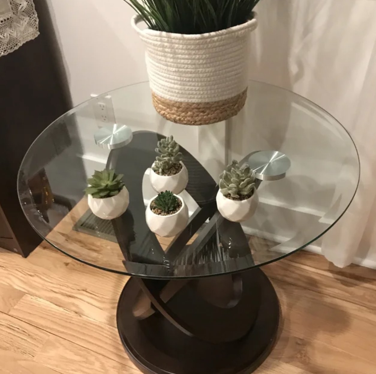 Reviewer&#x27;s photo of the four potted succulents on a glass end table