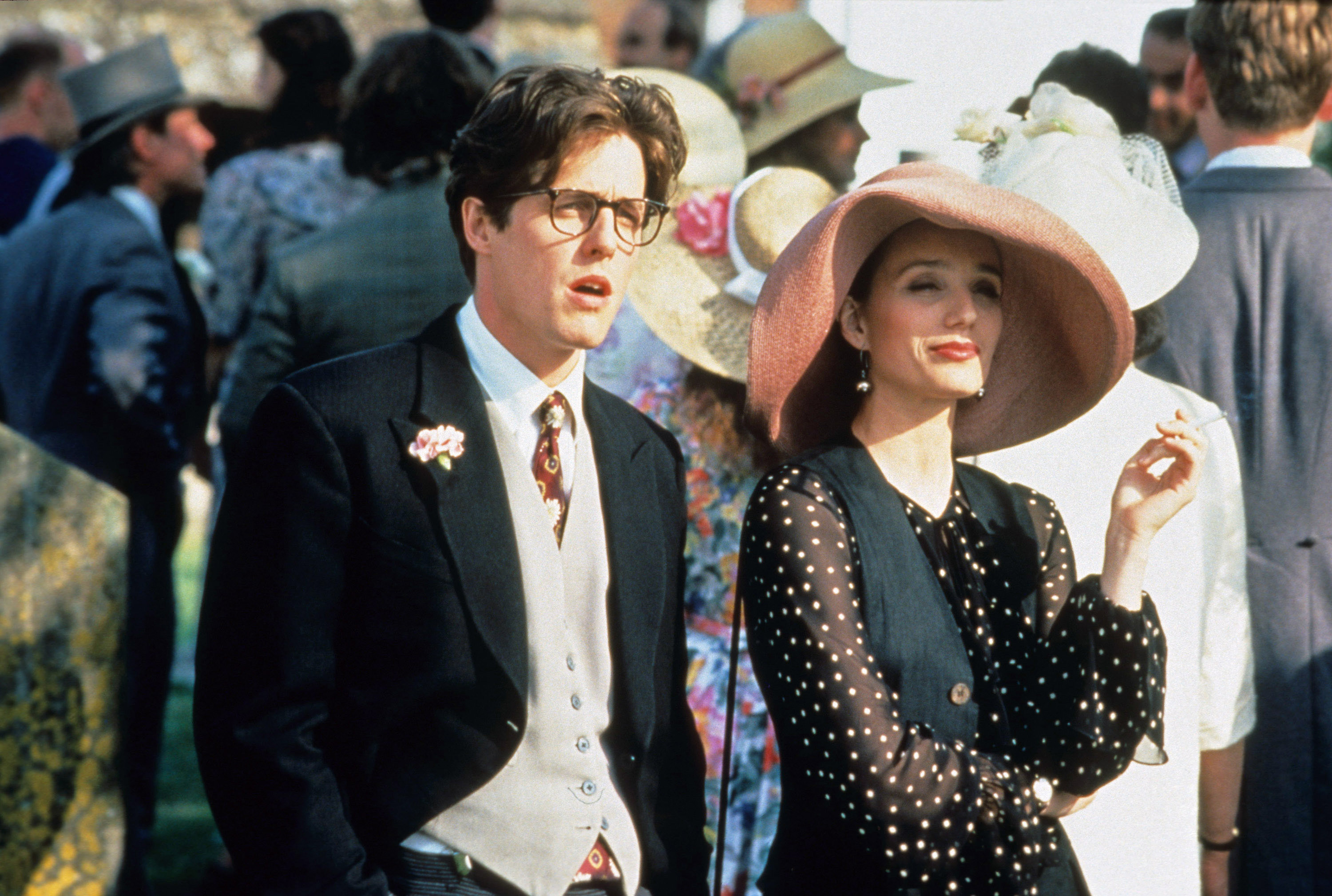 Hugh Grant, Kristin Scott Thomas in 90s wedding guest attire in four weddings and a funeral