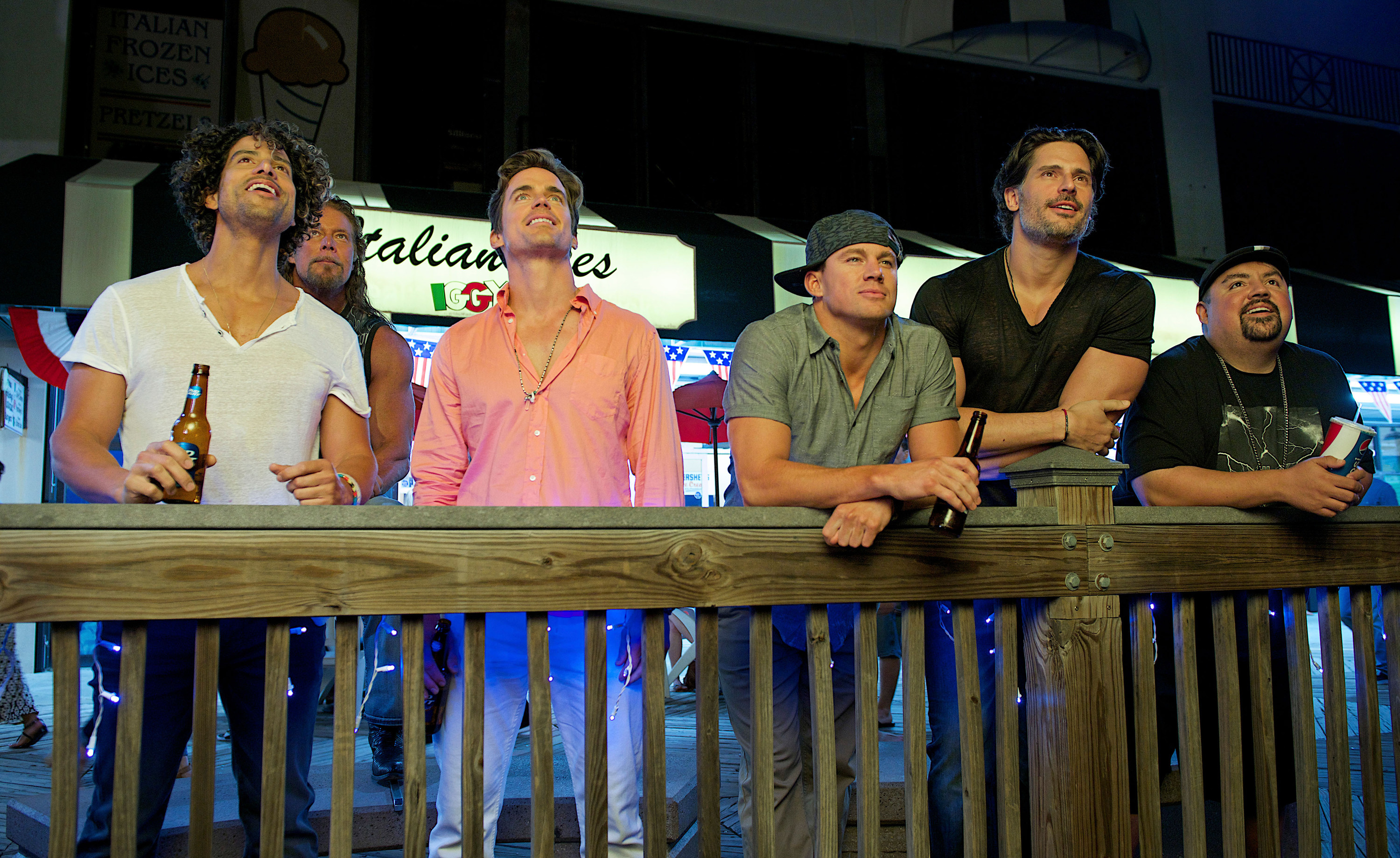 Adam Rodriguez, Kevin Nash, Matt Bomer, Channing Tatum, Joe Manganiello, and Gabriel Iglesias leaning over a railing in magic mike XXL
