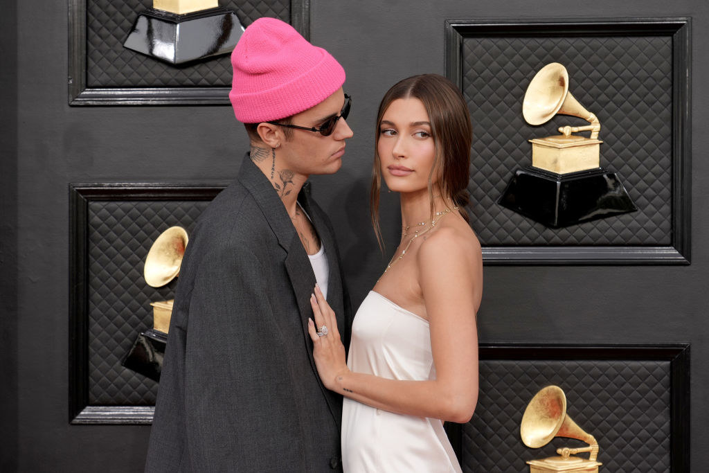 Justin looks at Hailey while they pose at the Grammys