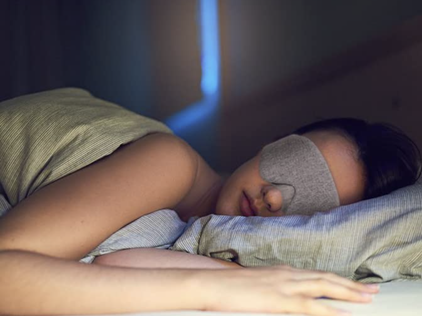 A person wearing the mask while they are sleeping in bed