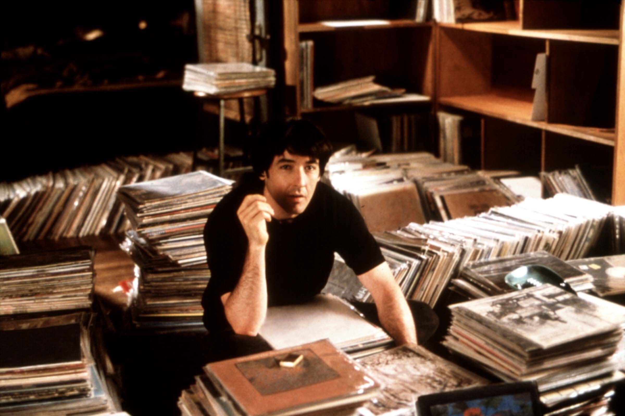 John Cusack surrounded by records