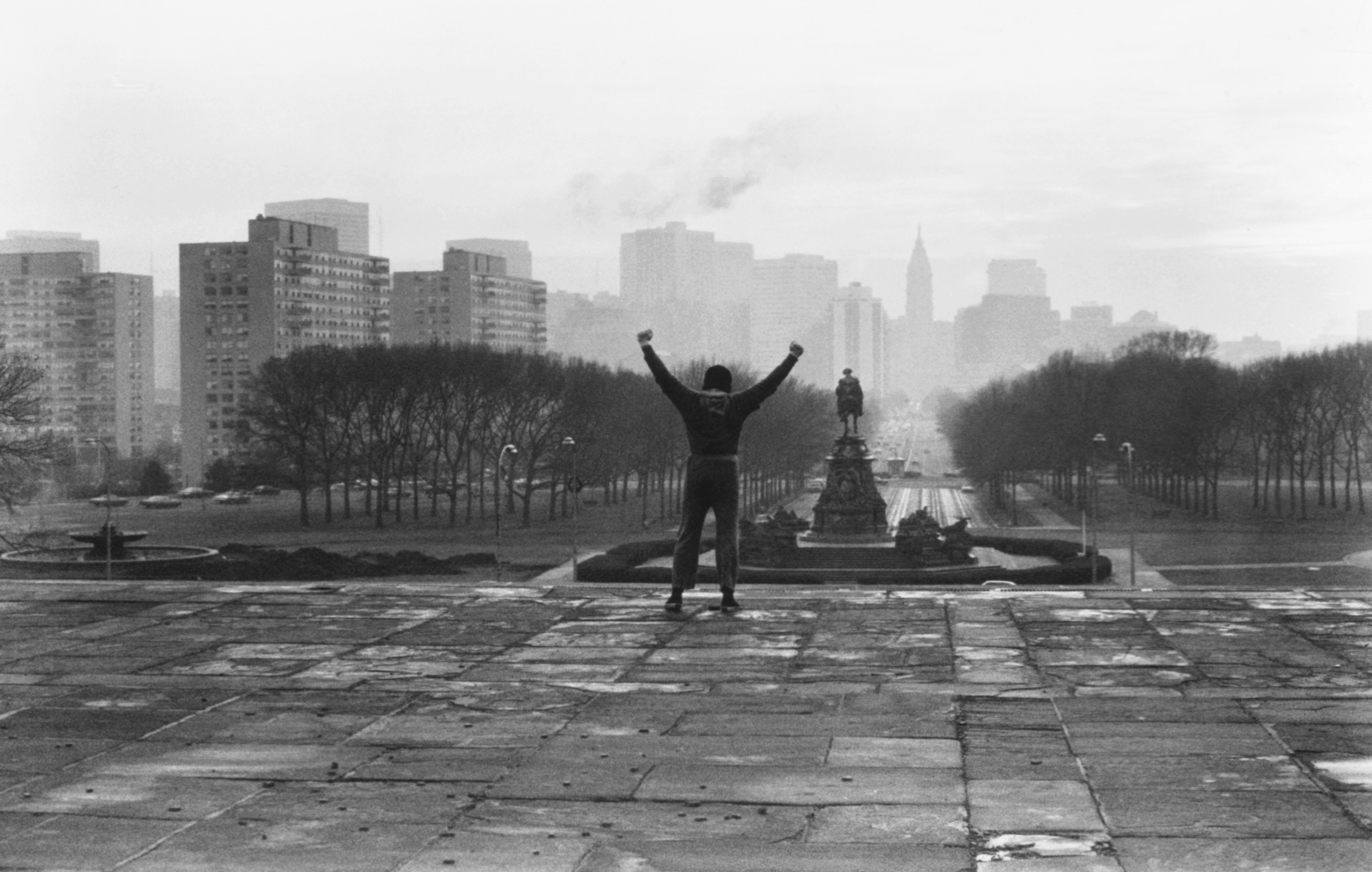 Sylvester Stallone raising his arms triumphantly at the top of the Philadelphia Museum of Art steps