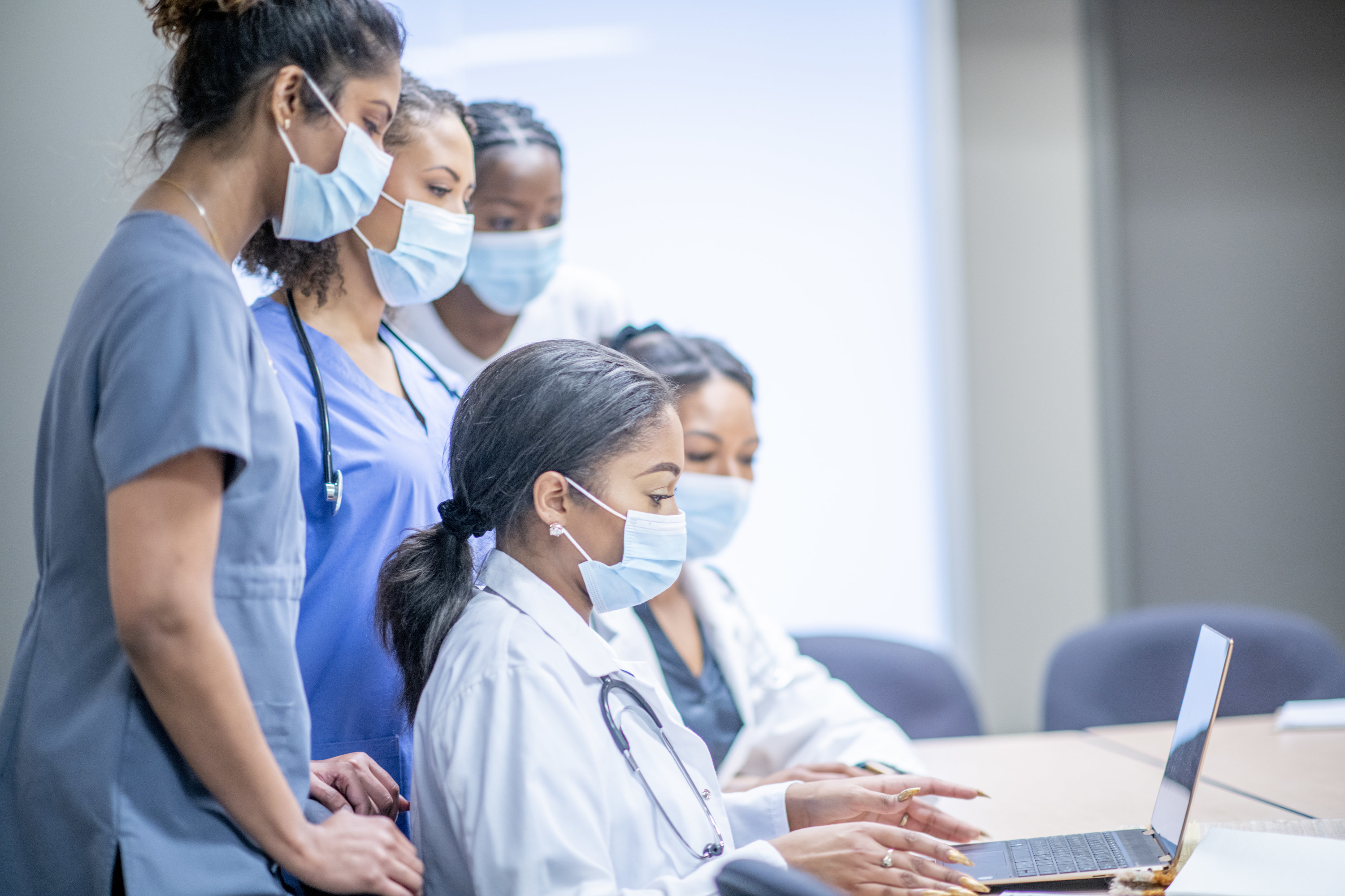 A group of medical school students looking at a laptop together