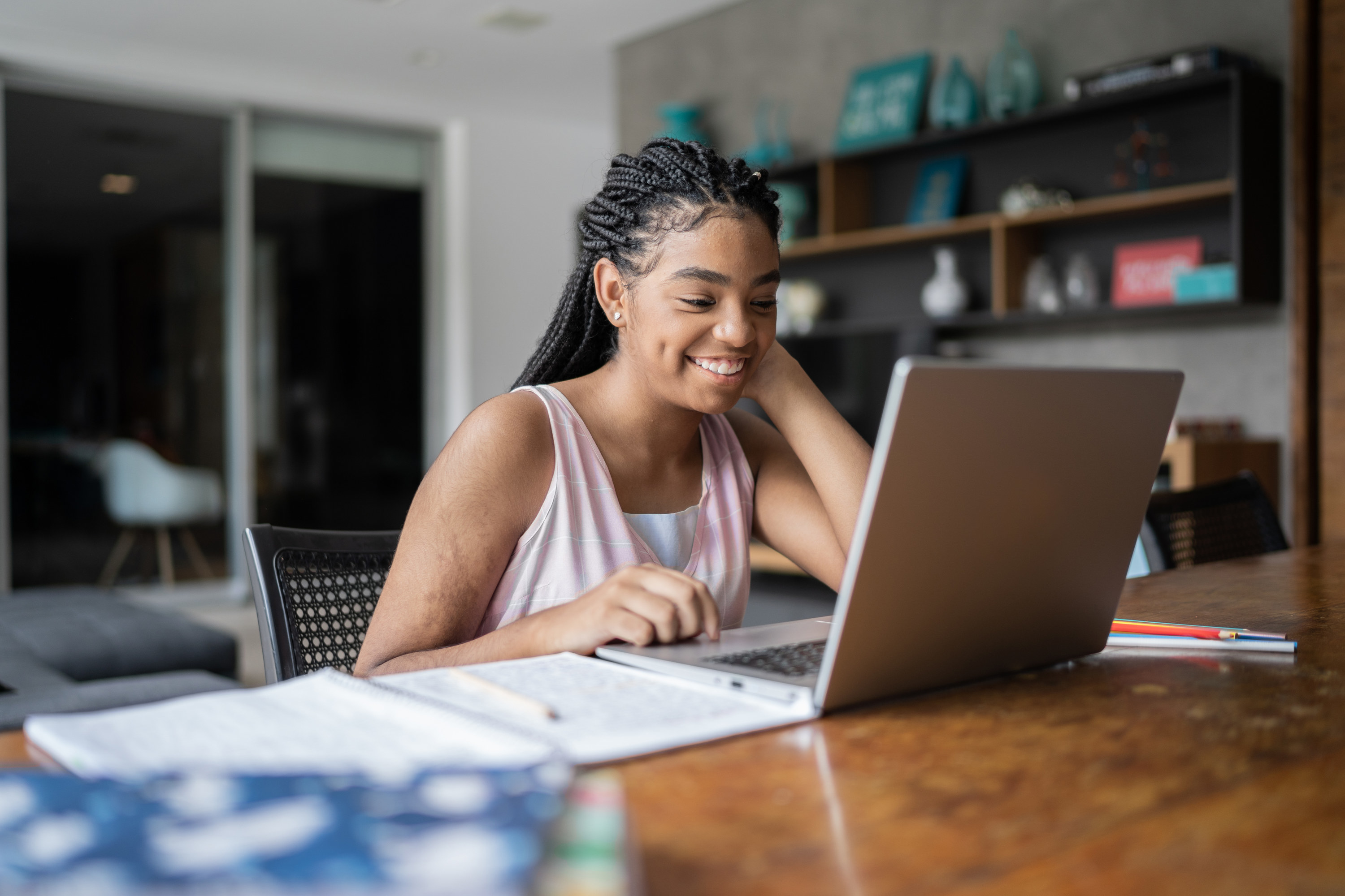 A woman sitting at a desk working on her laptop at home