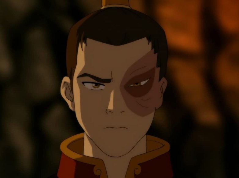 zuko is a man wearing his hair in a high ponytail and a collared shirt. he has one brow furrowed and his mouth in a line, but one of his eyes has the skin ripped off of it and around it