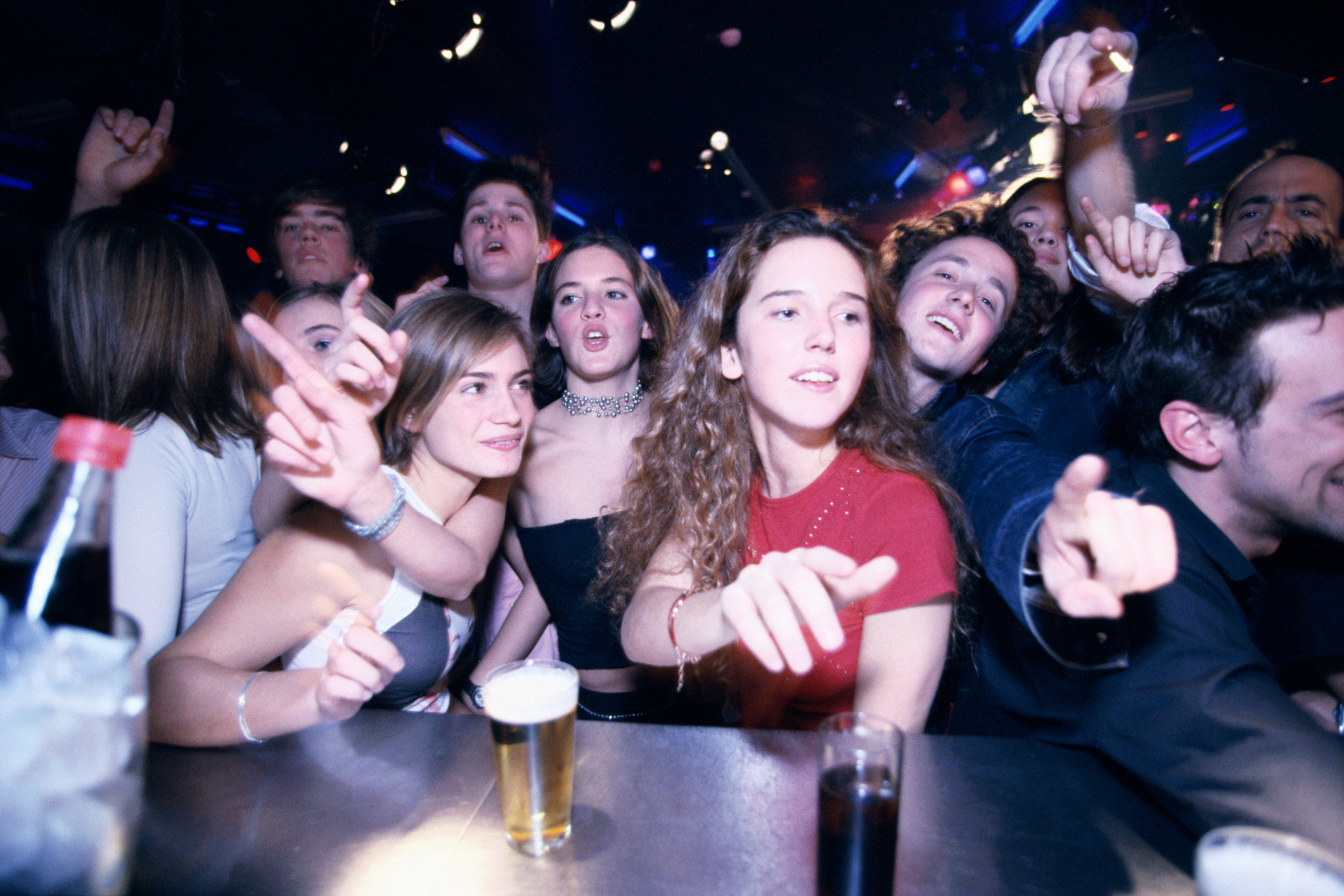 a group of young drinkers crowding the bar
