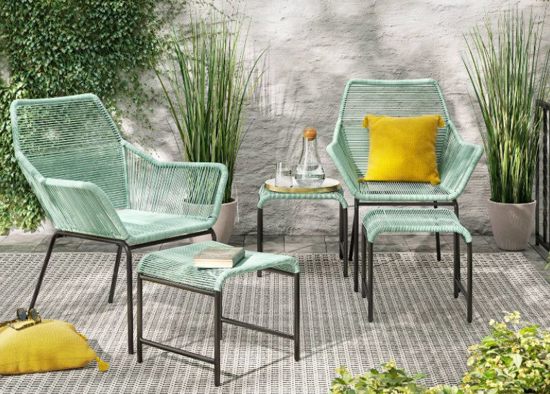 A patio set with two chairs, two ottomans, and a side table. Bright teal color and string style seats/foundations with black metal legs.