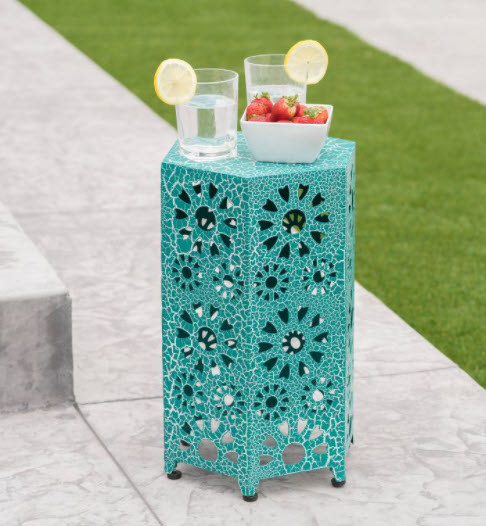 A small hollow hexagon shaped side table with crackle teal coloring. Iron material and short legs.