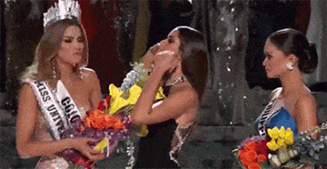 A presenter removing the Miss Universe crown from Miss Colombia and giving it to Miss Philippines