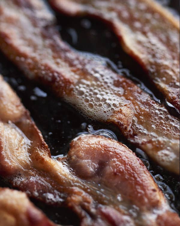 Bacon strips cooking on a skillet