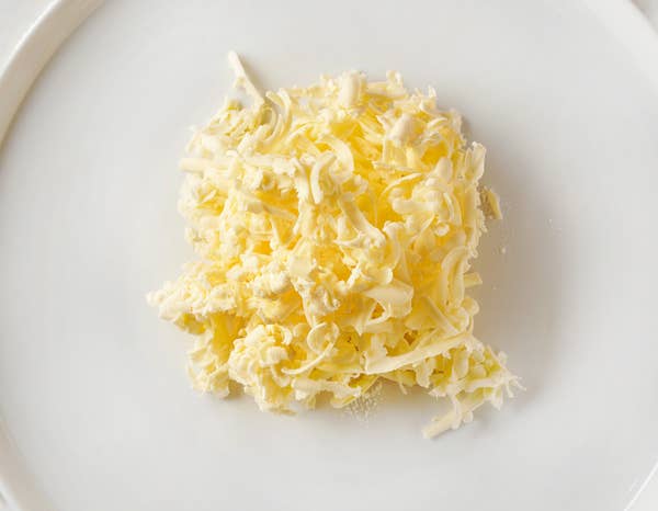 Cold grated butter on a white plate