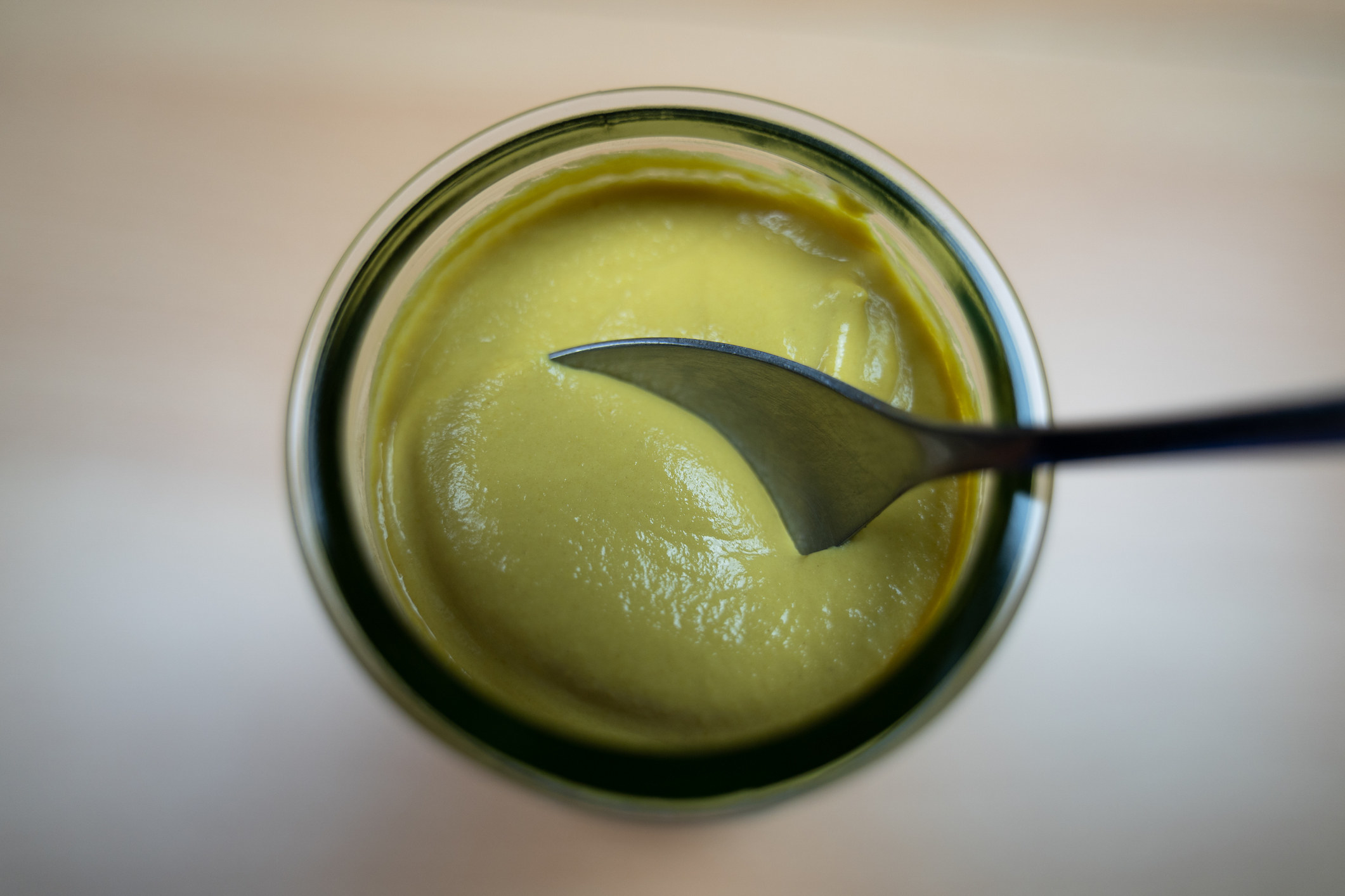 A spoonful of yellow mustard from the jar