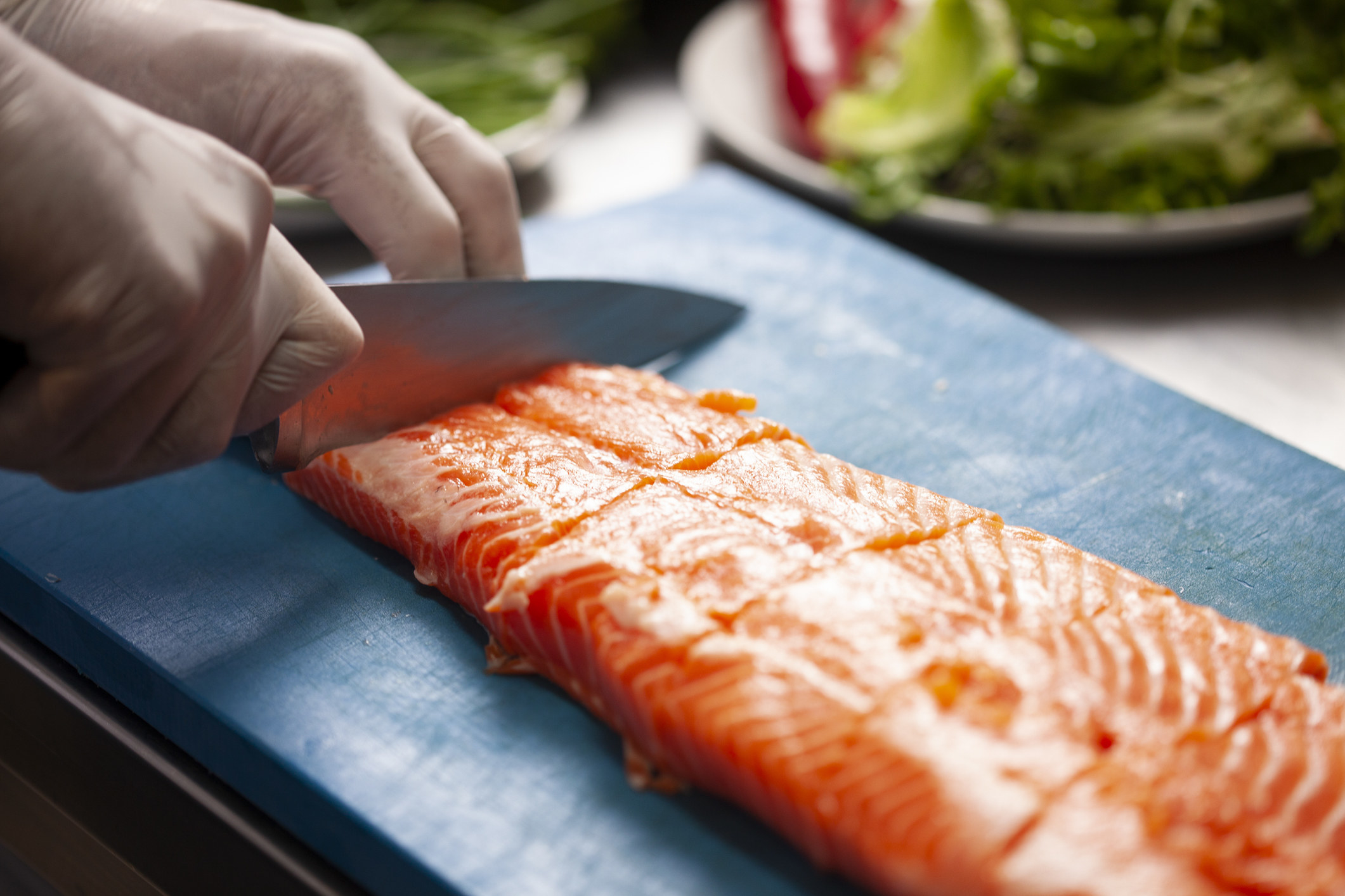 A person preparing salmon