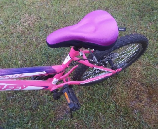 reviewer showing the cushion in purple on their daughter&#x27;s bike
