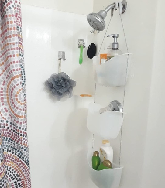 reviewer photo showing the shower caddy hanging in their shower