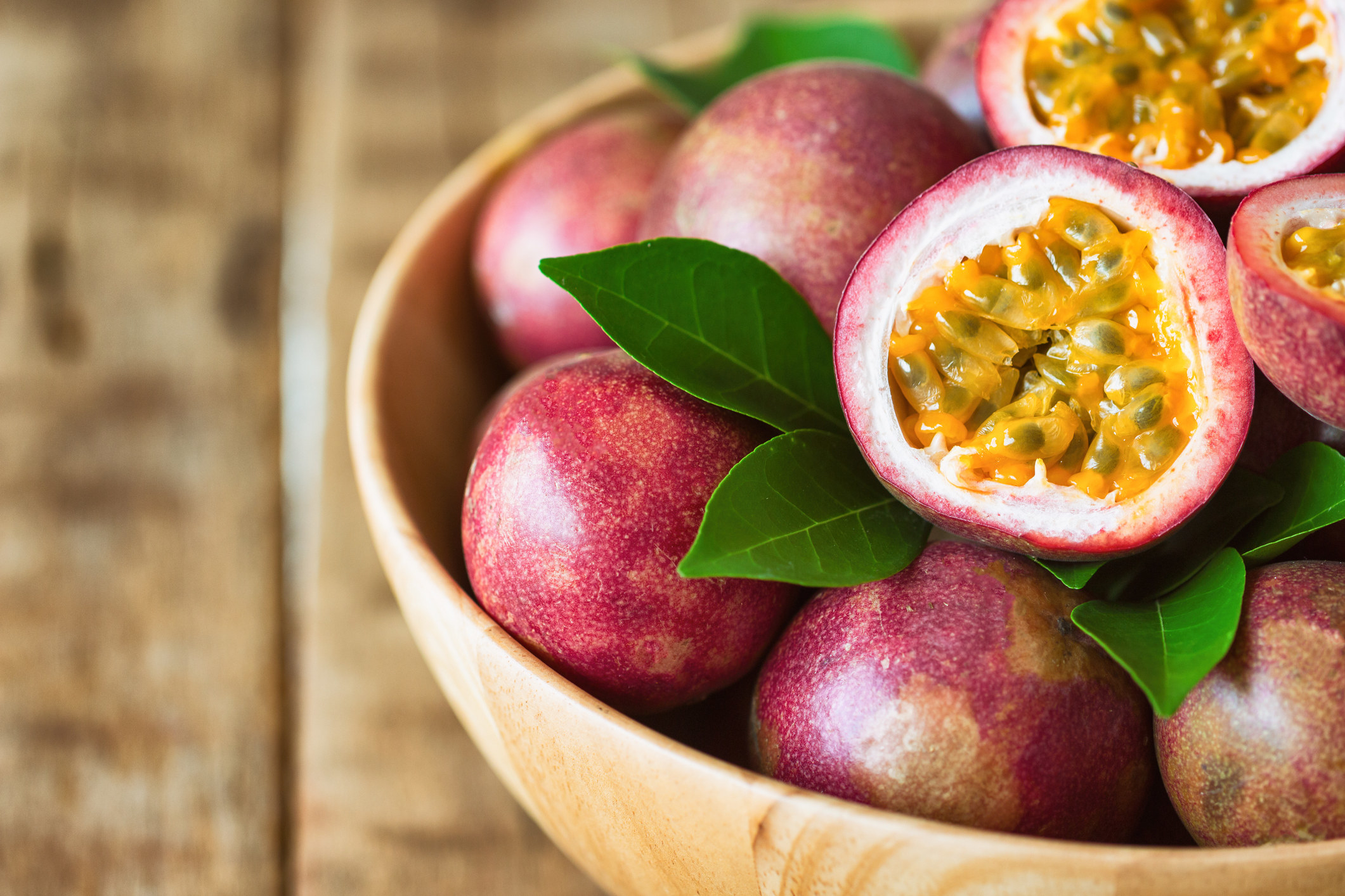 bowl of passionfruits with one cut open
