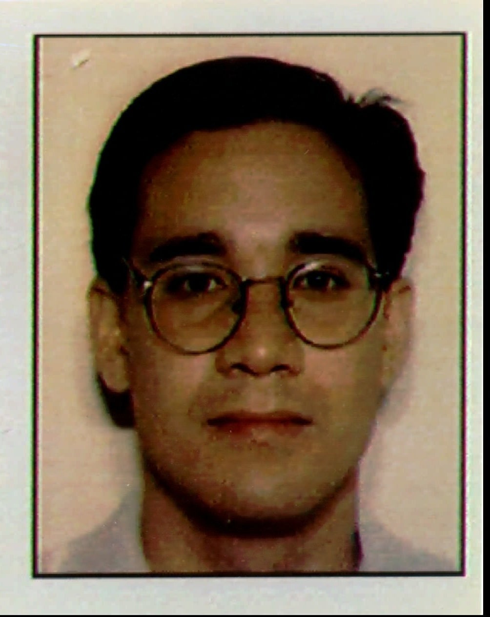 Mug shot of Andrew wearing circular glasses and short hair