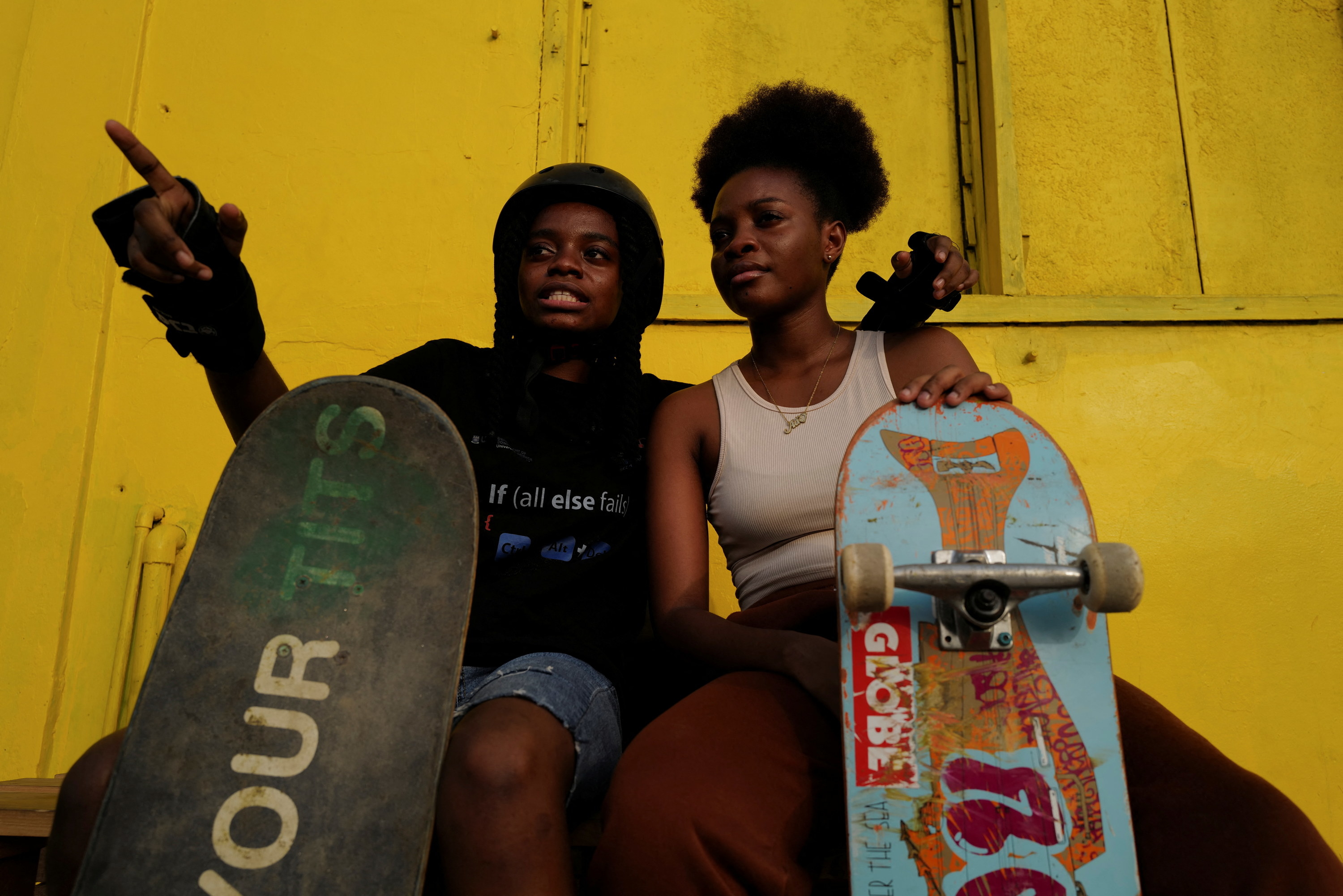Twins Adelaide and Adeline Yeboah, 18, sit with their skateboards before practicing