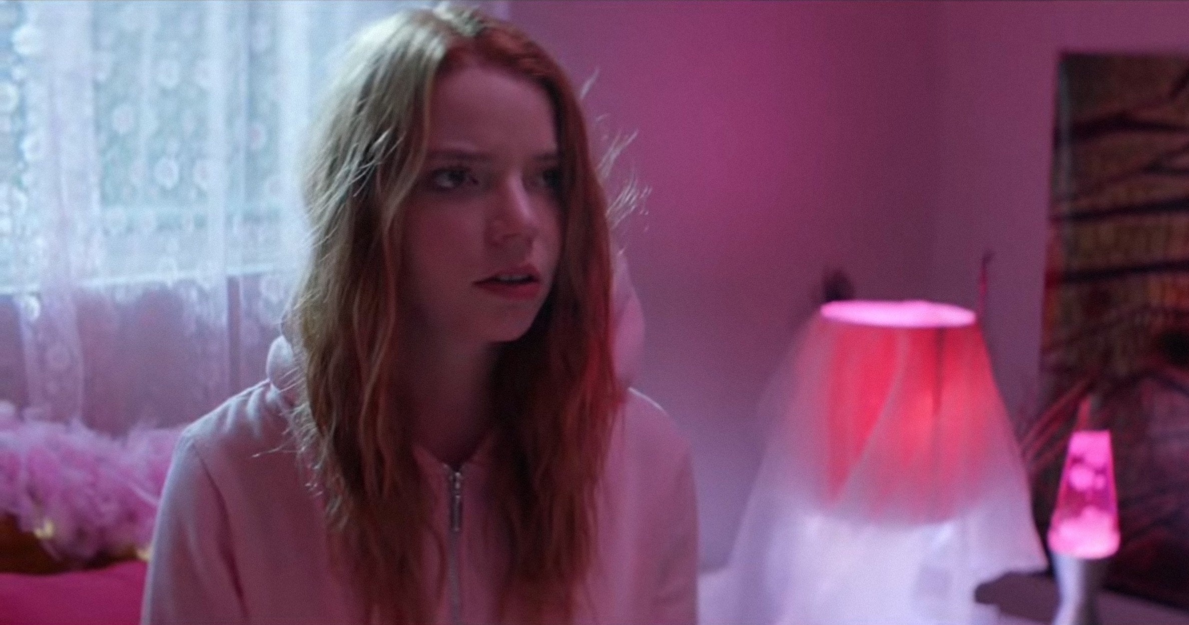 Anya Taylor-Joy sits in pink lighting