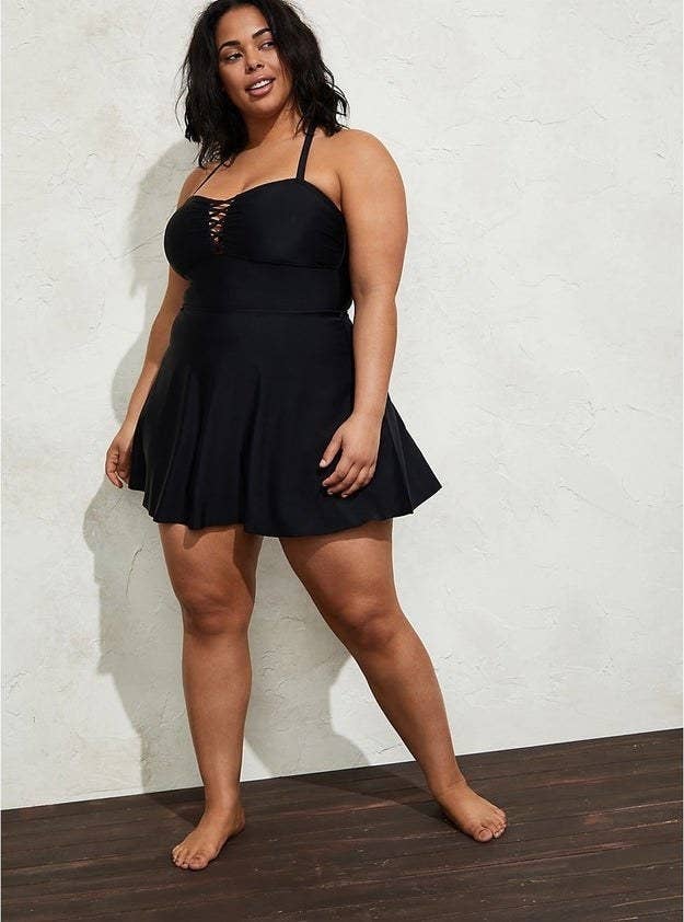 plus-size model wearing a black swimsuit dress with a crisscross detail on the chest