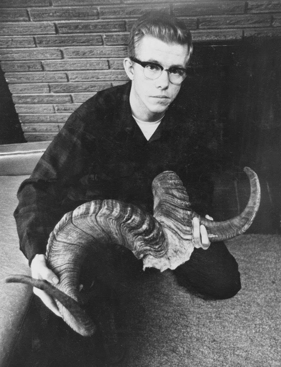 Robert wearing glasses and a flannel posing with large animal horns