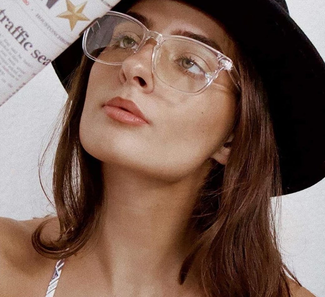A person looking up while wearing a pair of the glasses with transparent frames