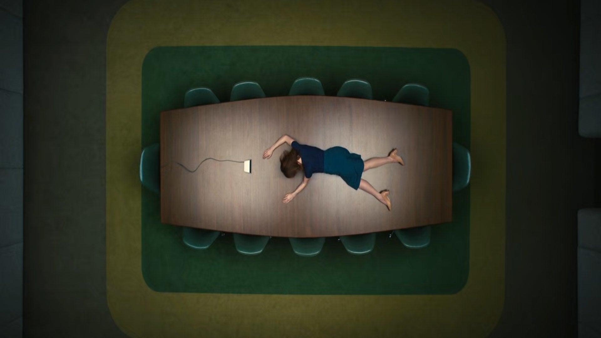 Britt Lower lies on her stomach on a big conference table