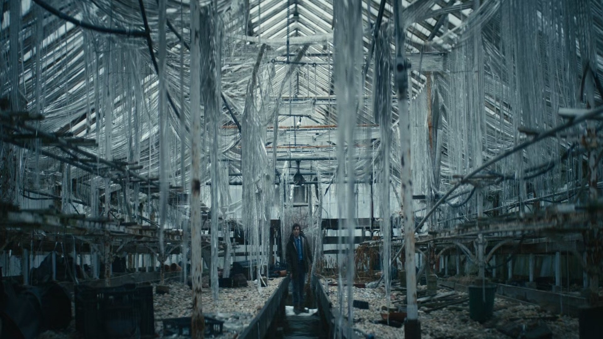 Adam Scott walks through an unkempt, dilapidated structure