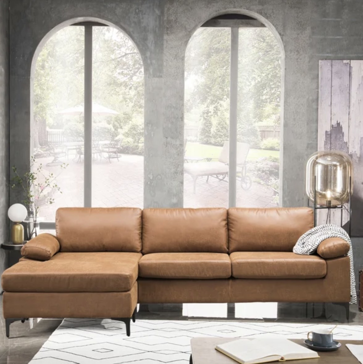 The light brown leather couch has two regular seating areas and a long chaise spot