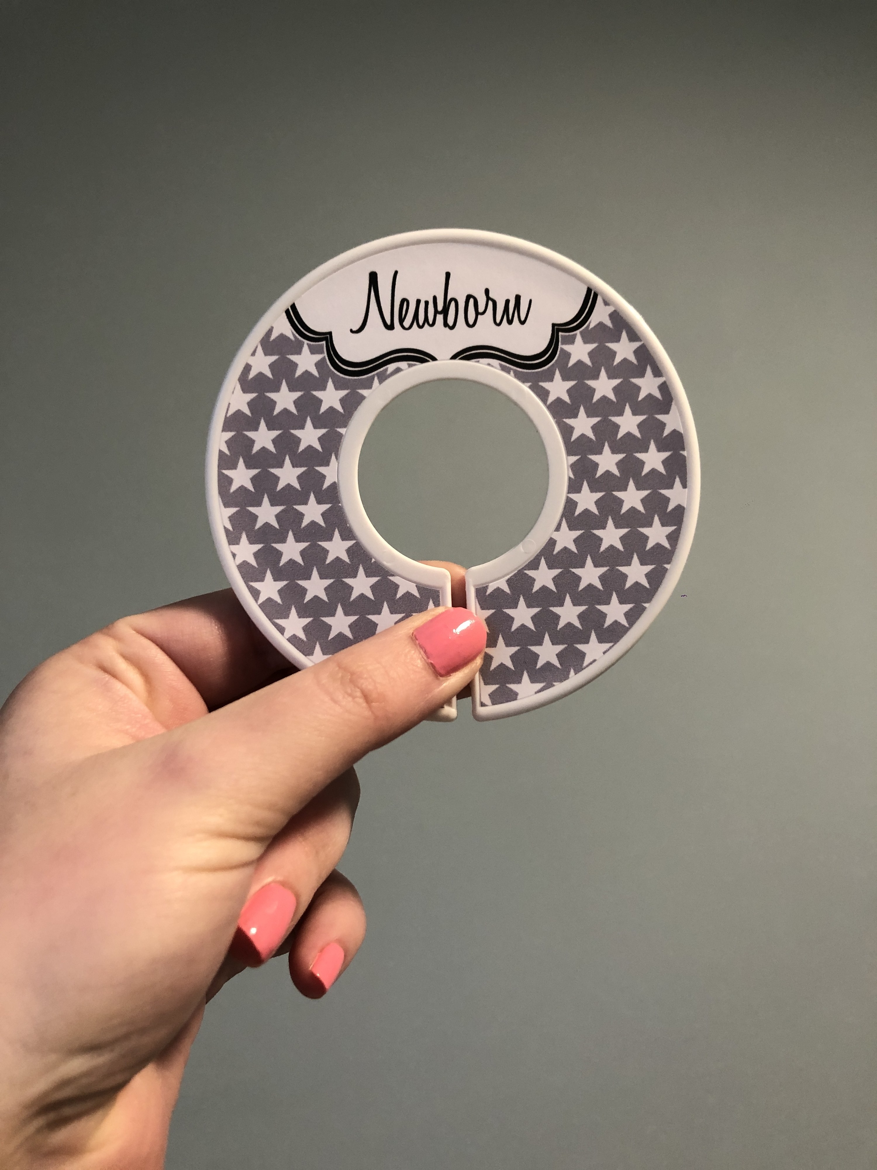 a plastic ring with grey stars on it and &quot;newborn&quot; written at the top