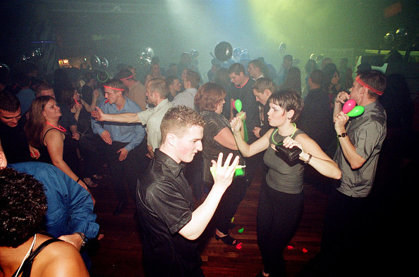 A group of people dancing at a night club.