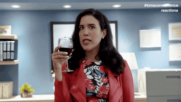 Nicole Power as Shannon Ross in &quot;Kim&#x27;s Convenience&quot; drinks from her wine glass and shows off her manager name plate