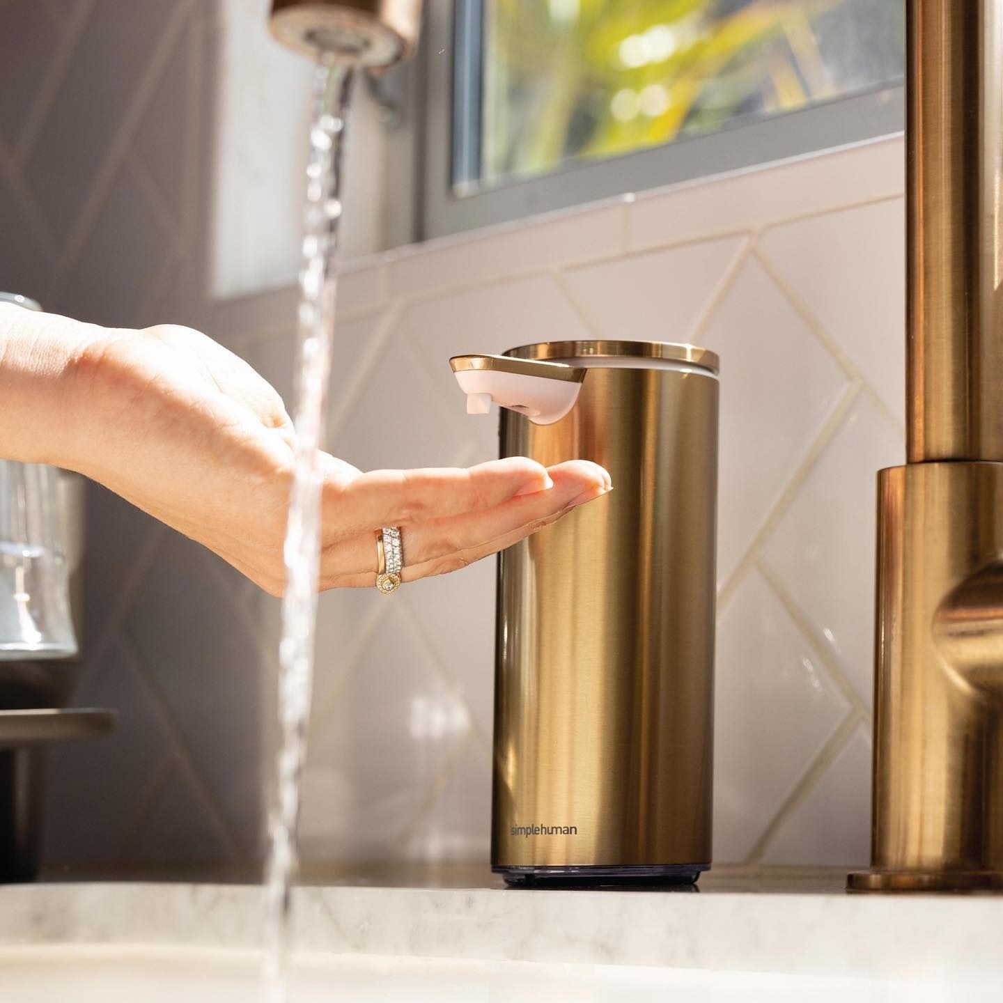 Silver automatic hand soap dispenser.