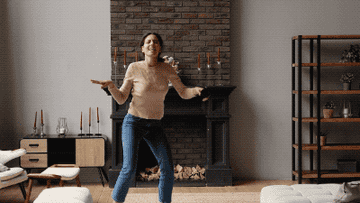 woman excitedly dancing by herself in living room