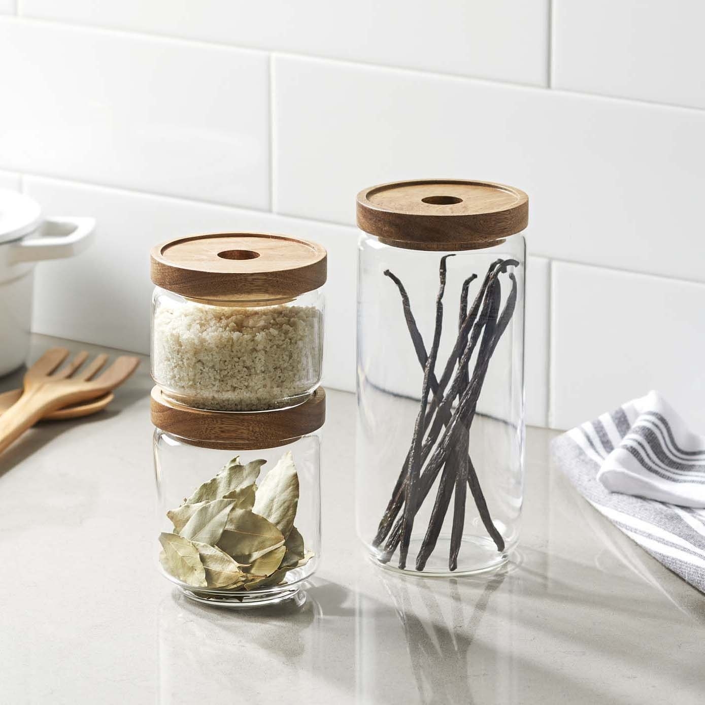 1 tall and 2 shorter glass containers with wooden tops
