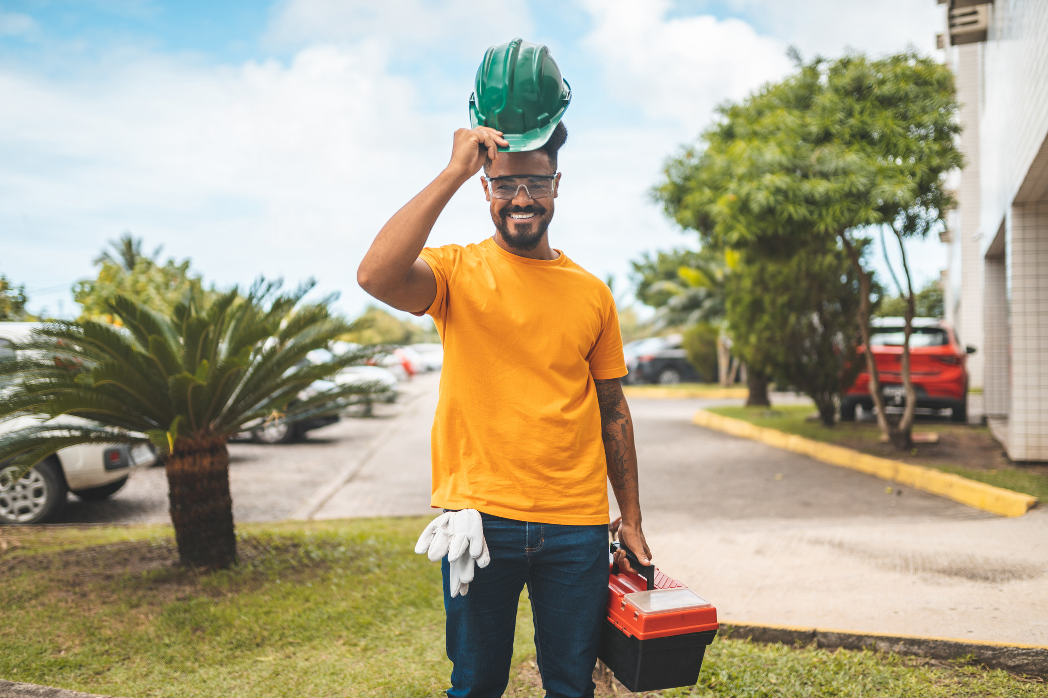 A contractor tips his hard hat toward the camera