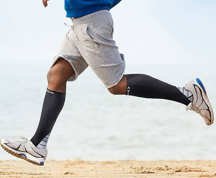 Someone wearing the compression socks and running on a beach
