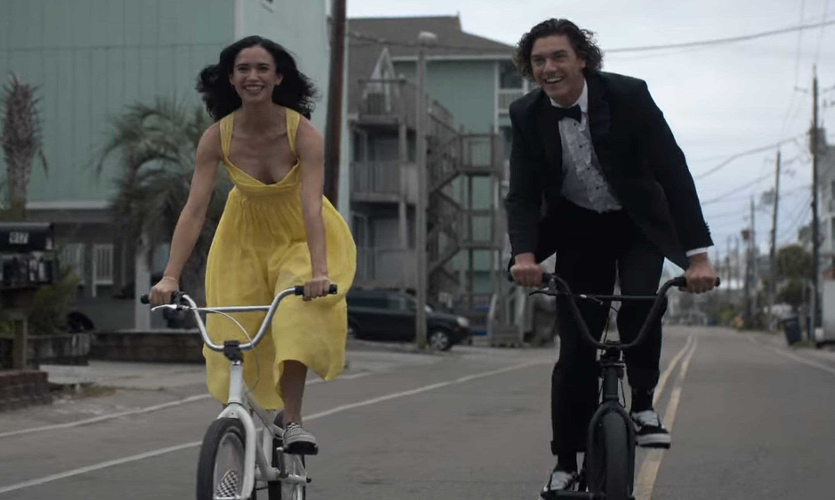 Auden and Eli riding bikes in their prom attire