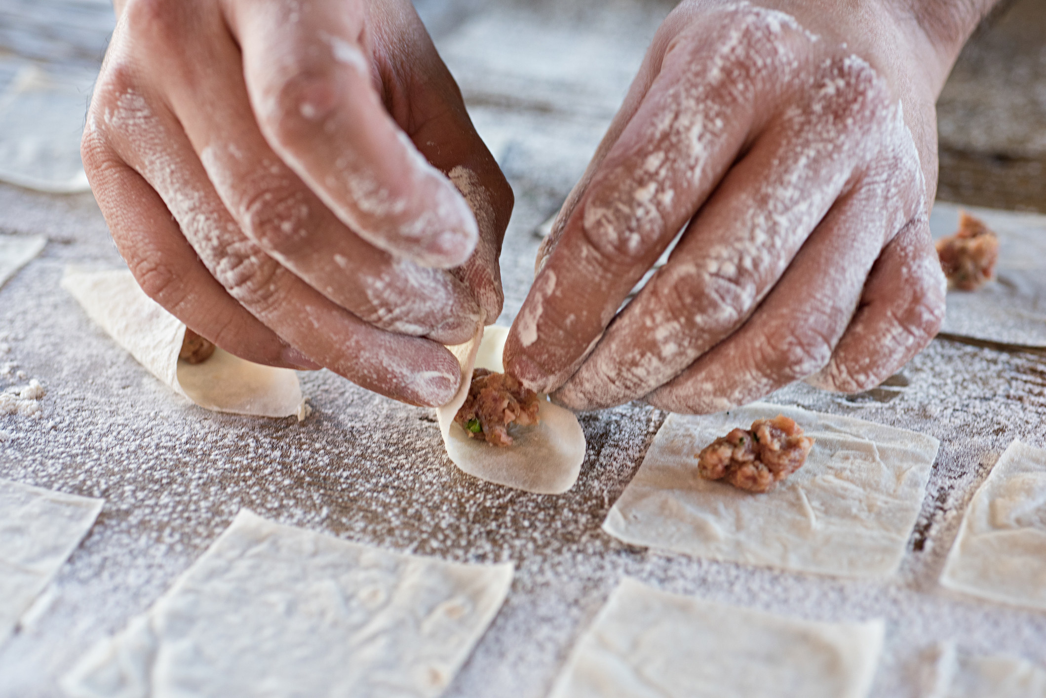Hands shaping tortellini.