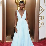 Lupita Nyong'o smiling at the Oscars in a long gown